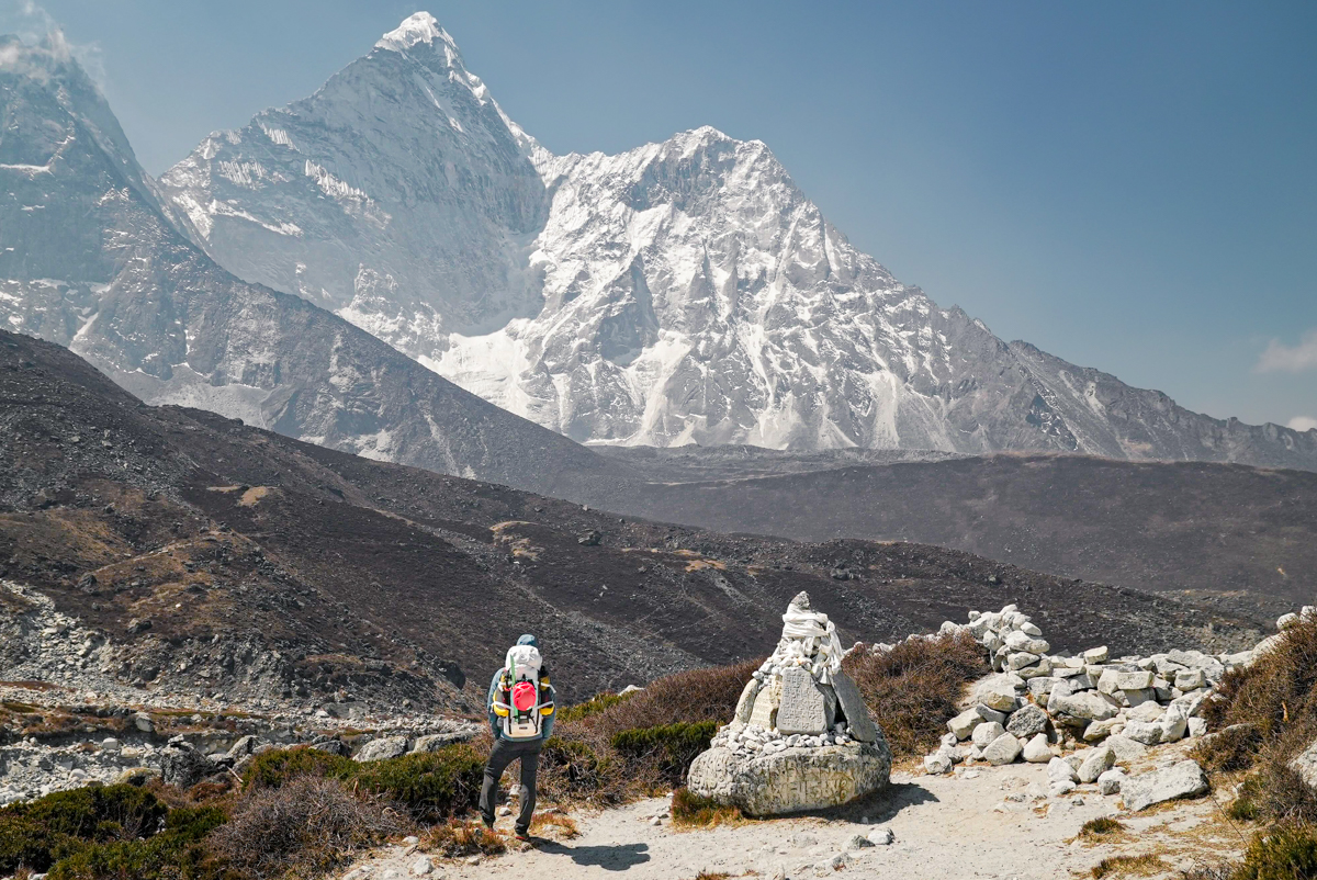 A hiker stops to admire the sky high peaks of the Himalaya