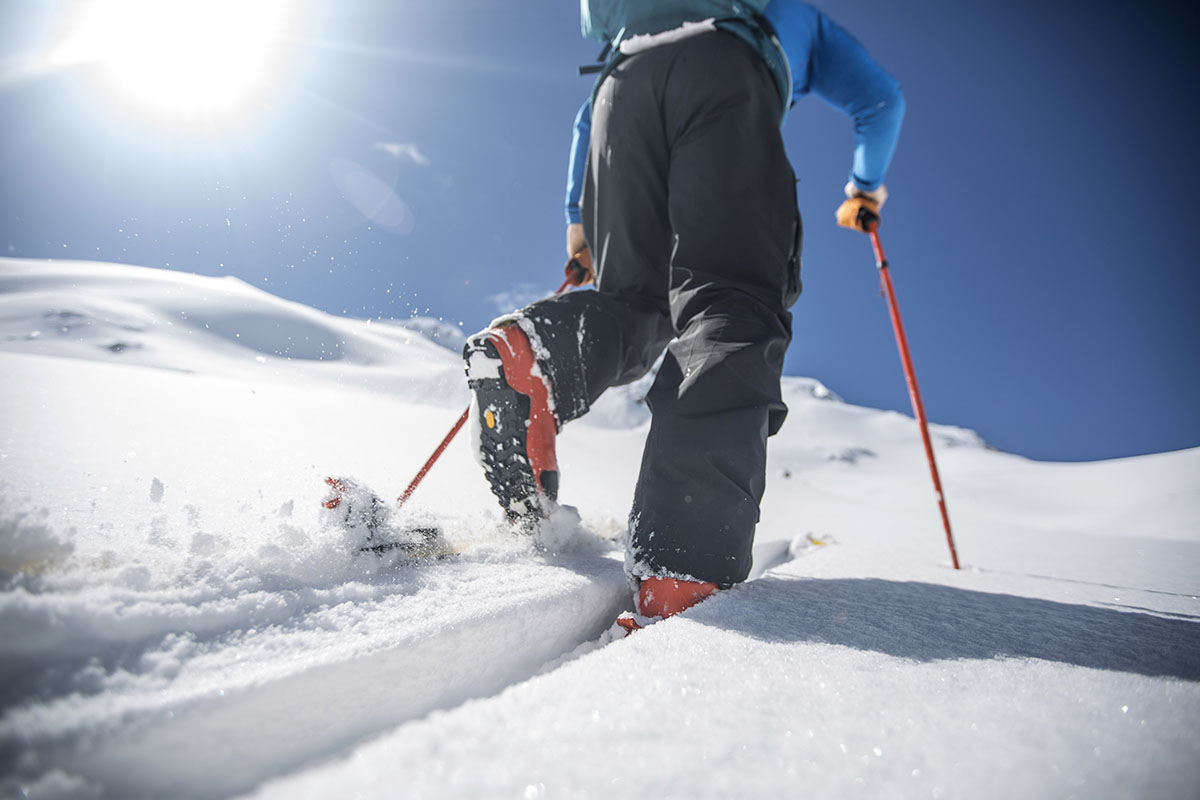 A skier uses backcountry boots to travel uphill in the snow.