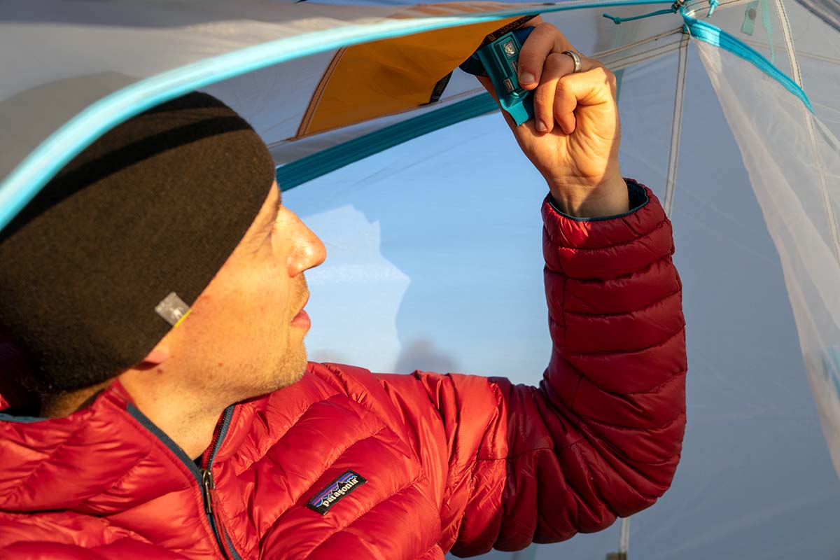 Retrieving headlamp from light diffuser pocket in the tent.